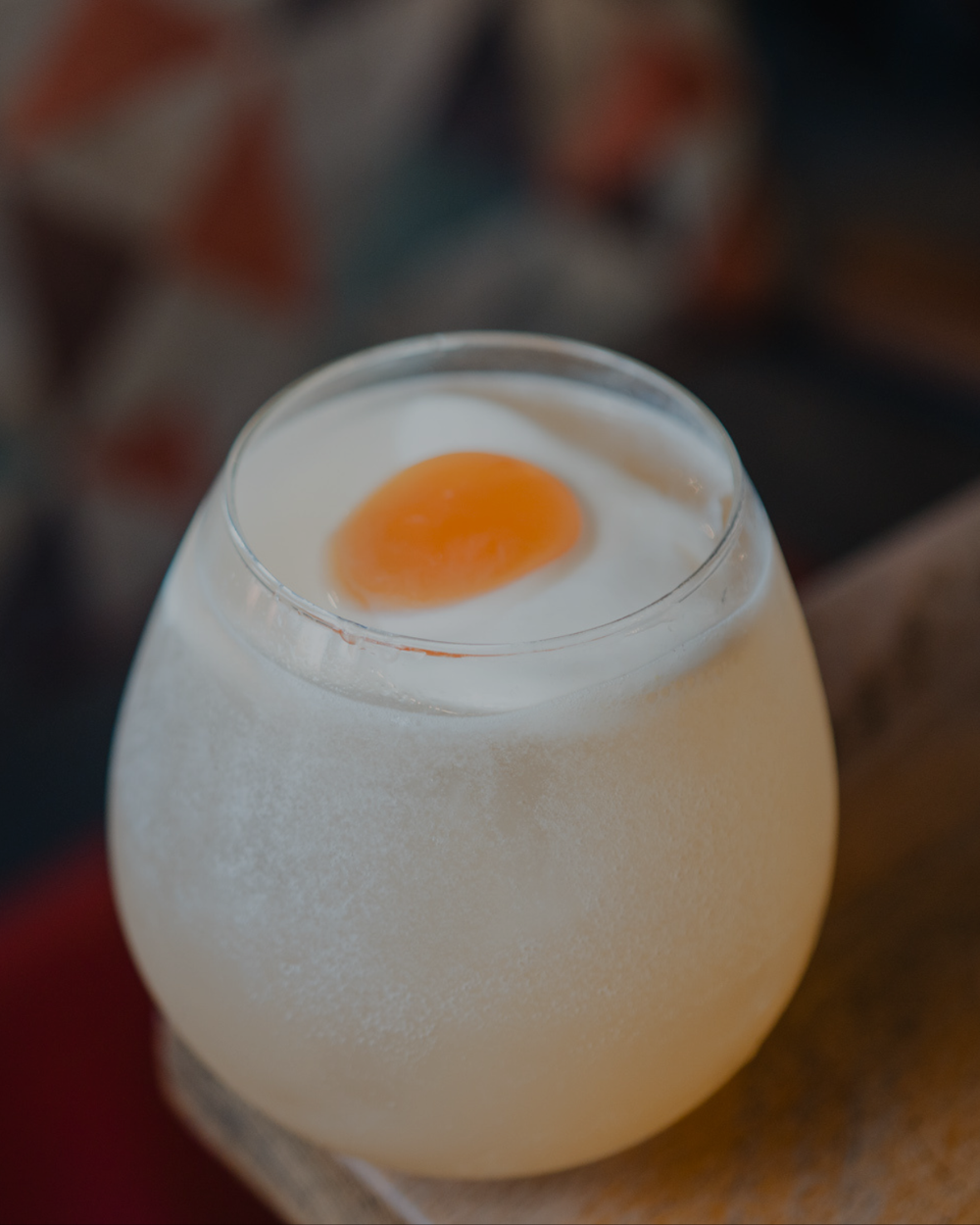 Breakfast at Mr Egg cocktail with a white foam top and orange centre resembling a fried egg