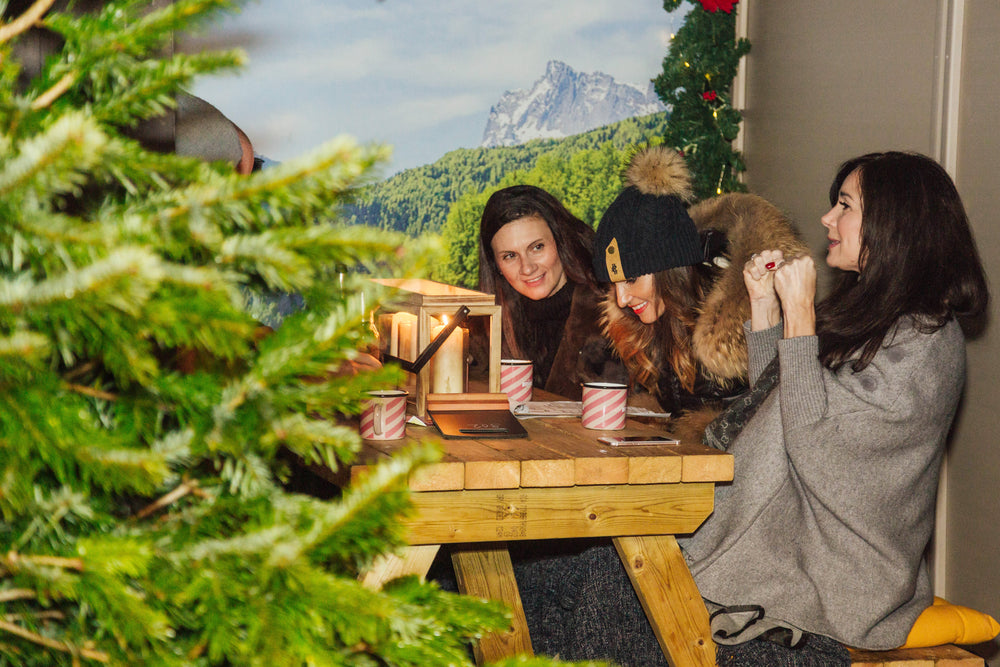 Festive Christmas chalet with illuminated garlands, Christmas decorations and cosy wooden seating, creating a warm alpine-inspired dining experience.