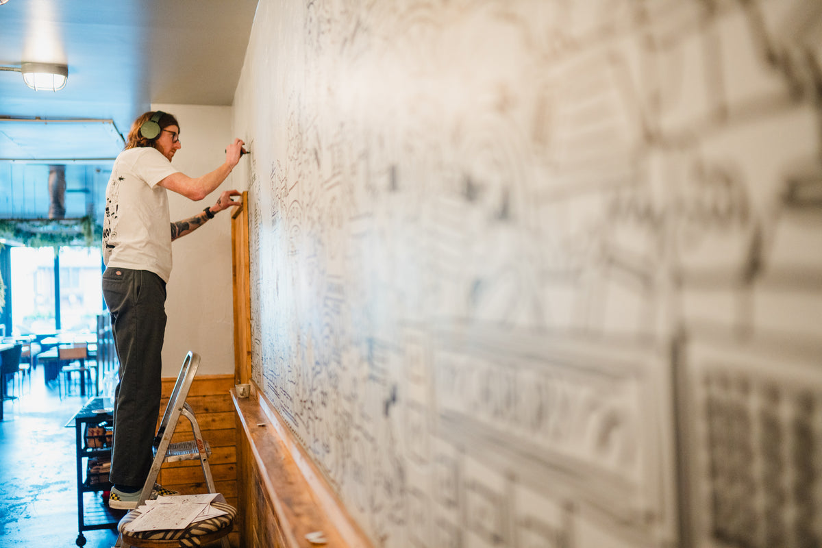 Artist Doodling Art on wall in Gas Street Social Birmingham