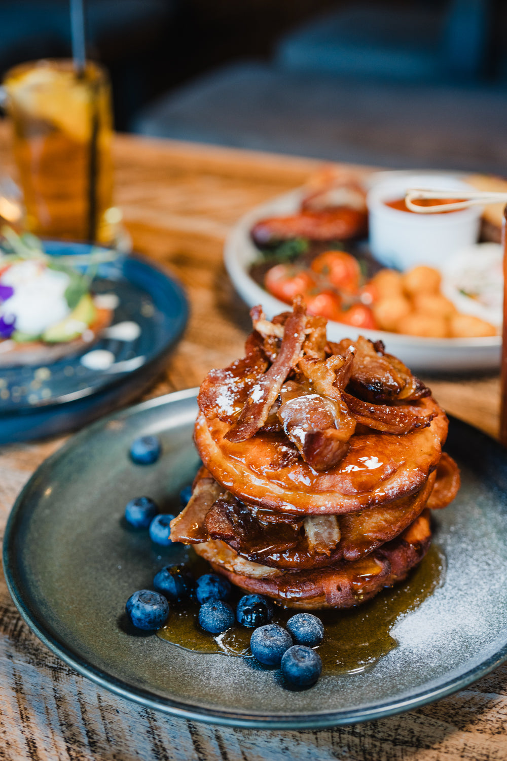 Stack of pancakes topped with crispy bacon, syrup and fresh blueberries at Gas Street Social Birmingham.
