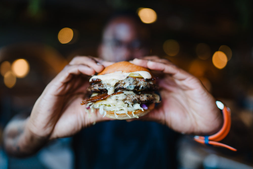 Double cheeseburger with melted cheese, crispy bacon and fresh slaw at Gas Street Social Birmingham.