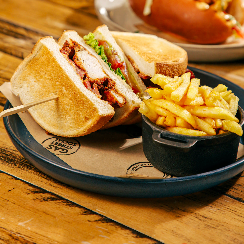 Freshly prepared chicken club sandwich with golden chips at Gas Street Social, a restaurant in Birmingham serving all-day dining and sharing plates.