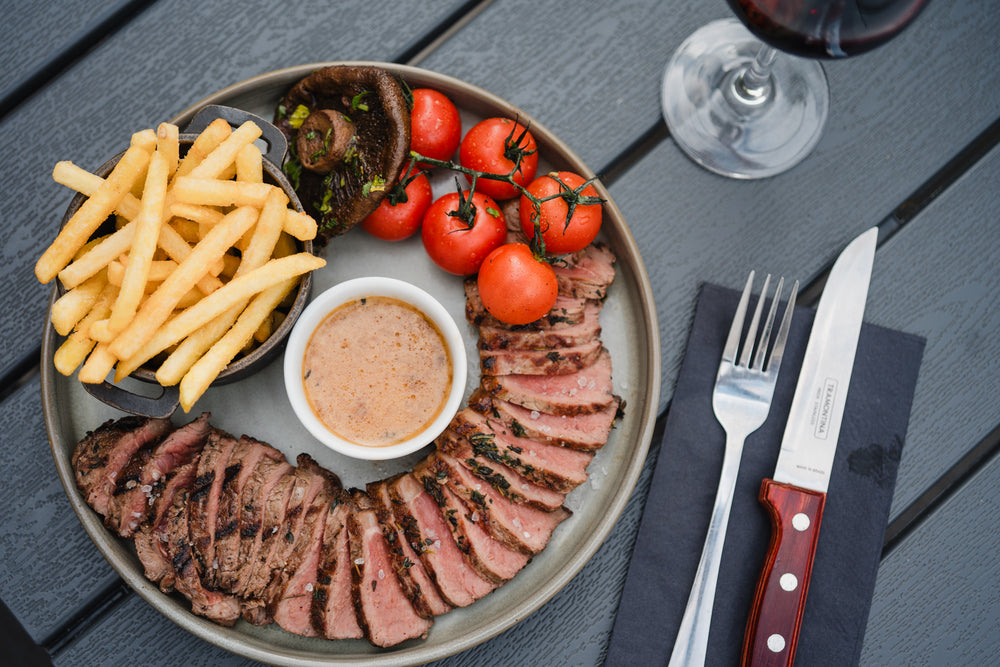 Freshly prepared grilled steak served with golden fries, roasted tomatoes, mushrooms and peppercorn sauce at Gas Street Social, Birmingham.