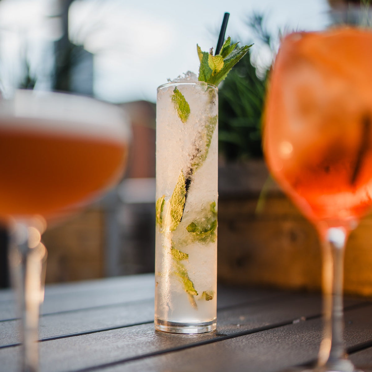Cocktails at Gas Street Social Birmingham featuring a refreshing mint cocktail, an orange spritz and a classic beer on the table at The Mailbox.