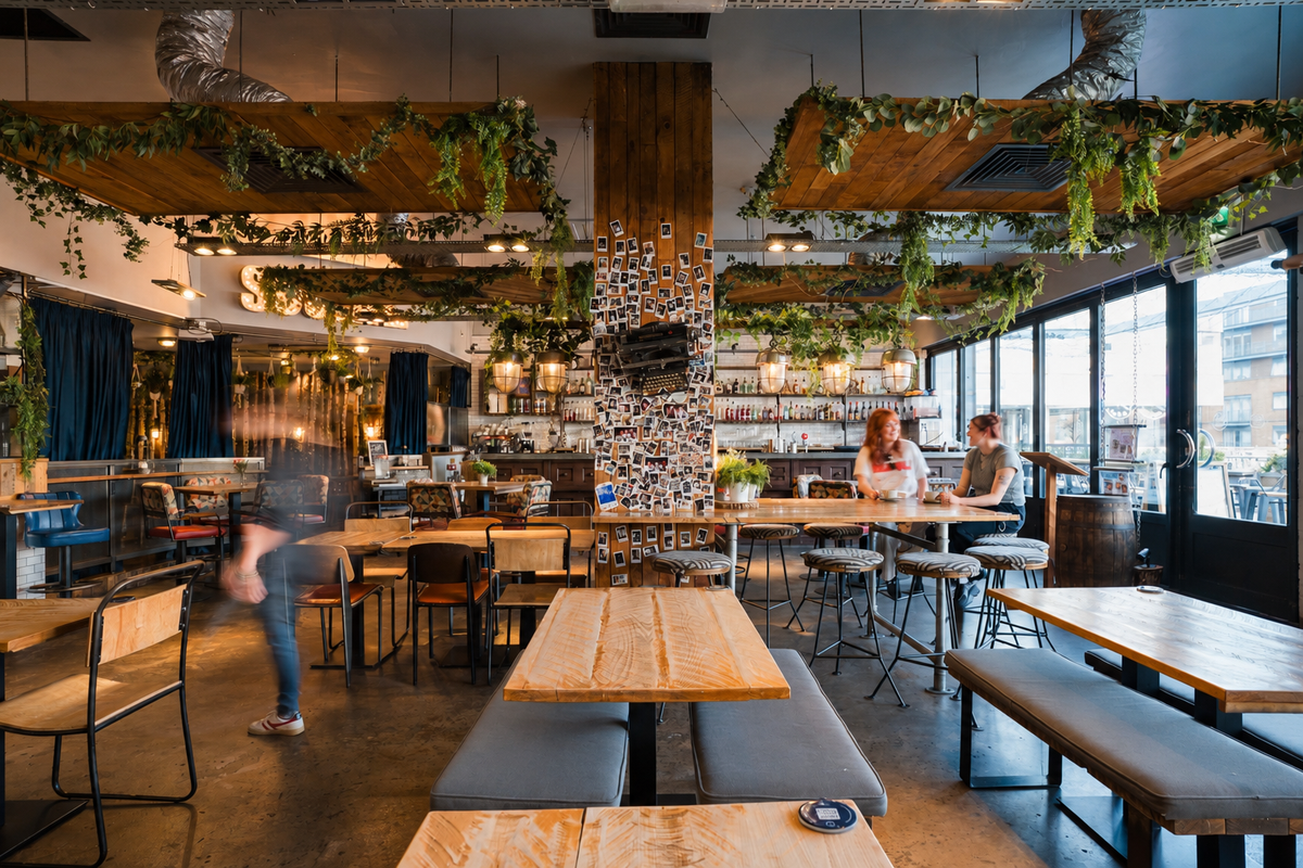 Communal tables and upholstered bench seating inside Gas Street Social at The Mailbox, Birmingham, providing a welcoming setting for group dining, birthday parties and celebrations.
