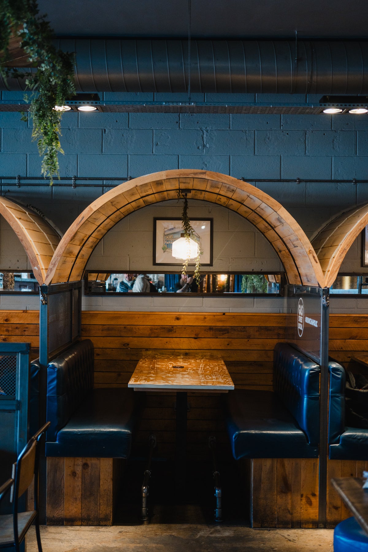 Intimate wooden booth seating with blue leather benches at Gas Street Social restaurant and cocktail bar in The Mailbox, Birmingham.
