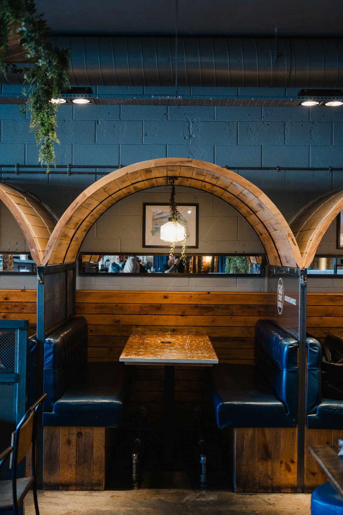 Intimate wooden booth seating with blue leather benches at Gas Street Social restaurant and cocktail bar in The Mailbox, Birmingham.